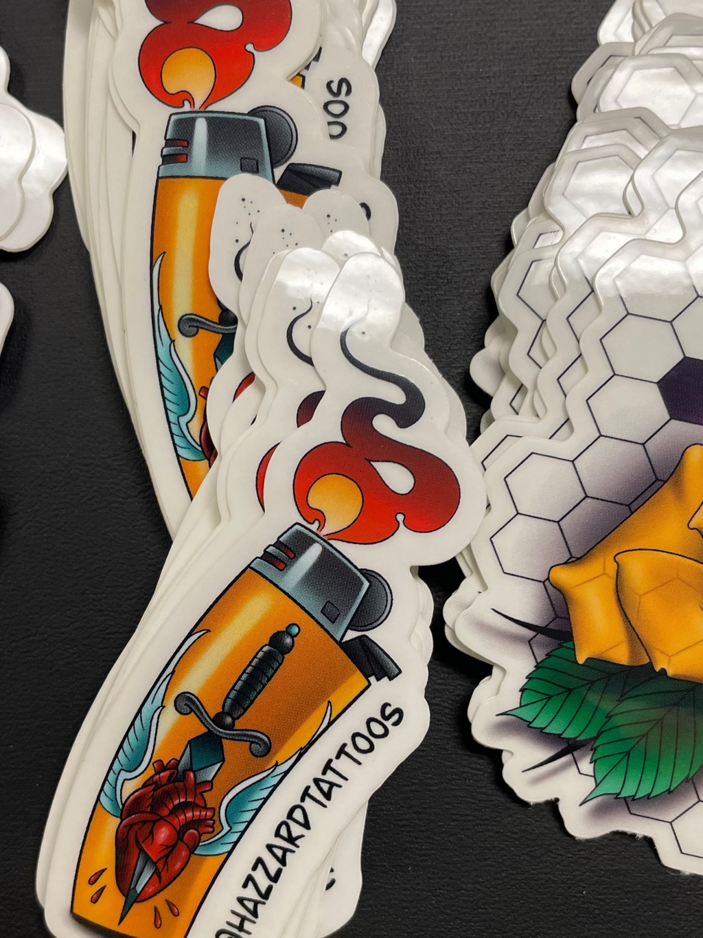 Collection of tattoo-style stickers on a black surface