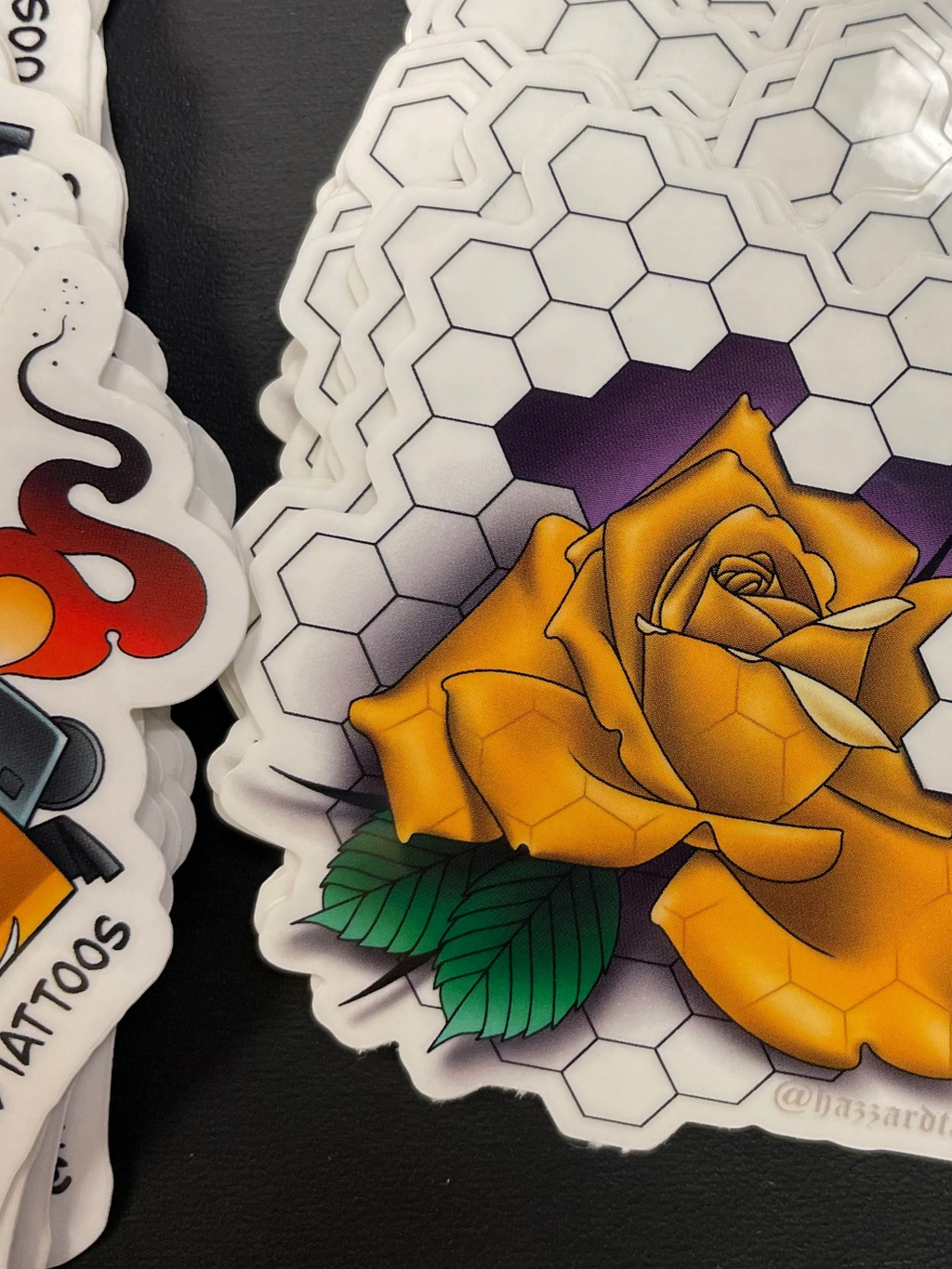 Stack of tattoo stickers with a yellow rose design on a black surface